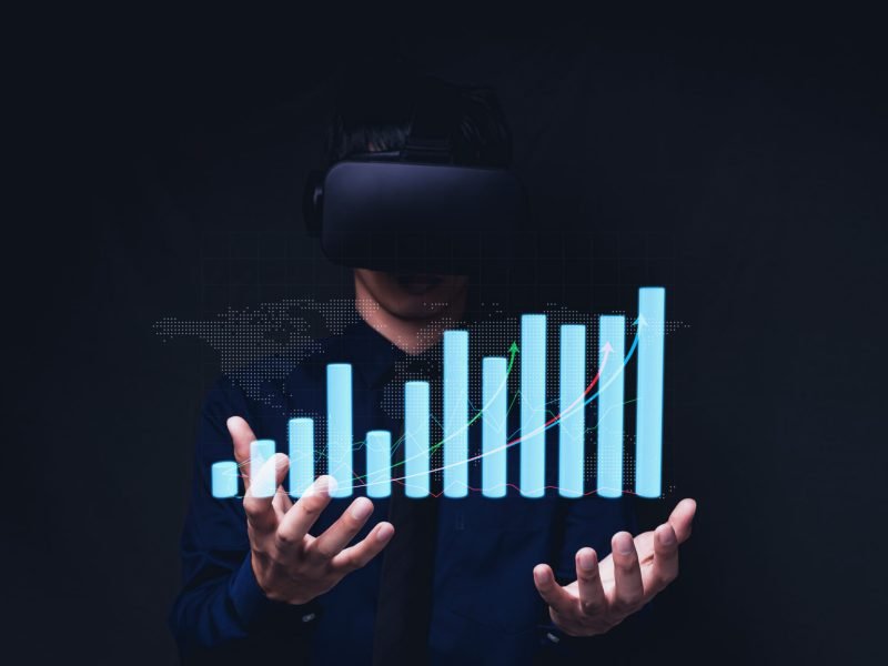 Businessman using Virtual Reality Metaverse glasses to virtual world showing bar graph business growth
